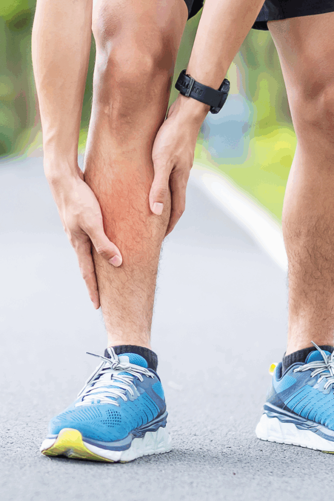 Person massaging shin muscles after a long-distance run