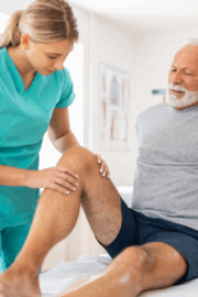 PT guiding patient through gentle exercises after knee surgery