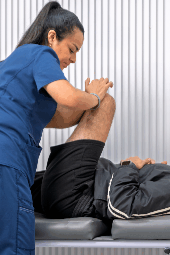 Physical therapist helping a patient with knee exercises in clinic.