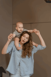 Physical therapist guiding parent through shoulder exercises.