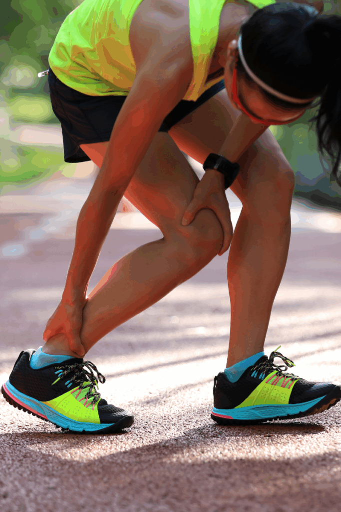 Runner warming up with calf stretch before a fall trail run in Maine
