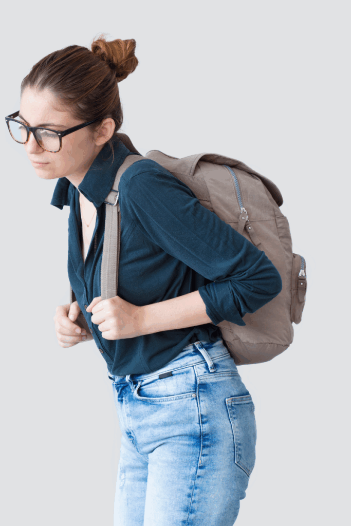 Student walking with heavy backpack on shoulders