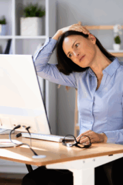Woman stretching arms overhead during TV break at home