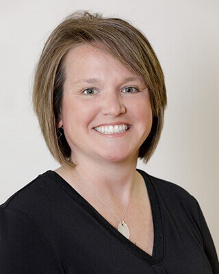 Jill Partridge of Reform Physical Therapy smiling at clinic, part of the corporate team in Maine