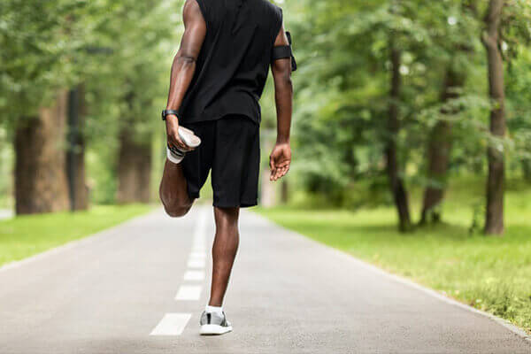 Runner stretching leg to prevent injury and support recovery with physical therapy