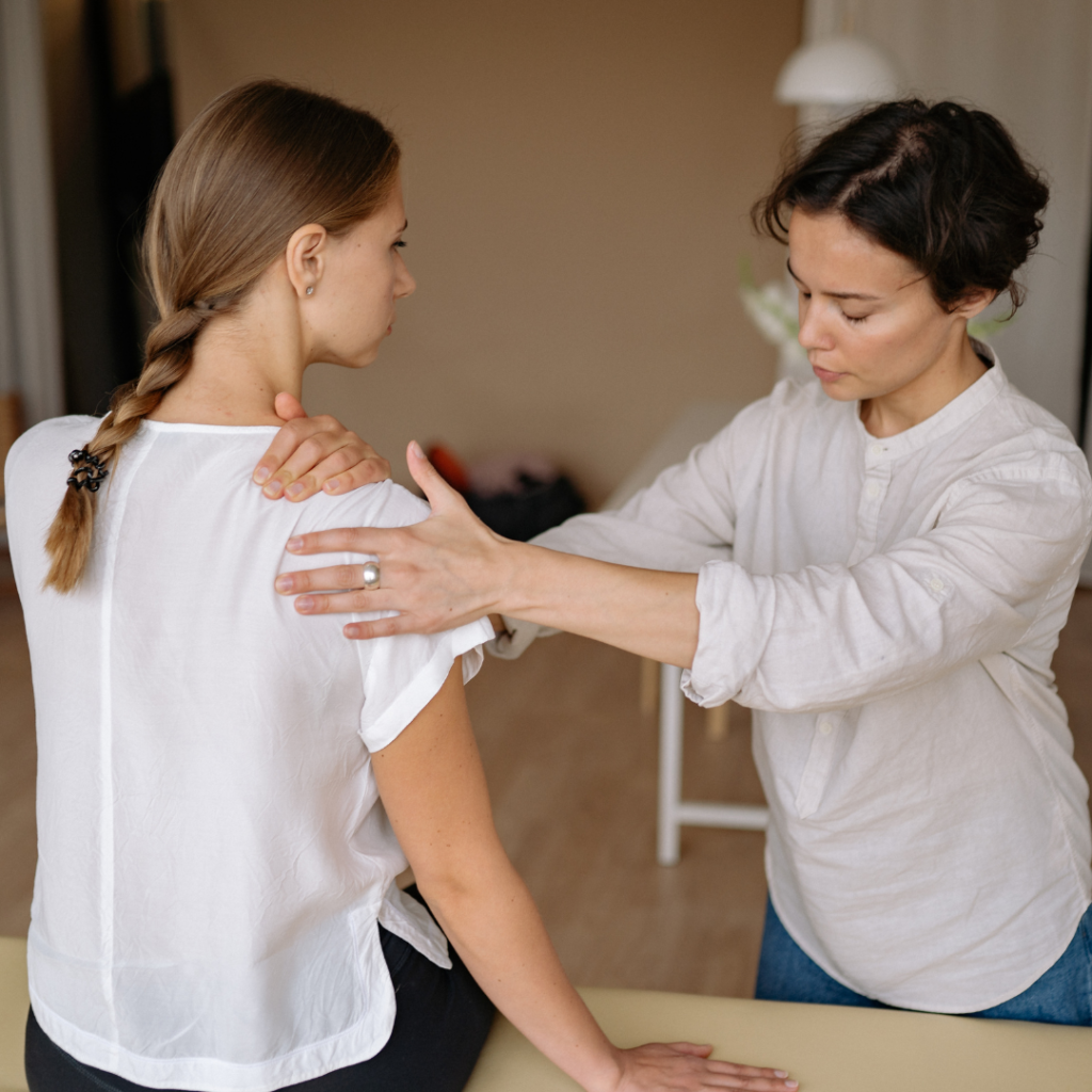 Physical therapist helping a mom with mom shoulder pain.