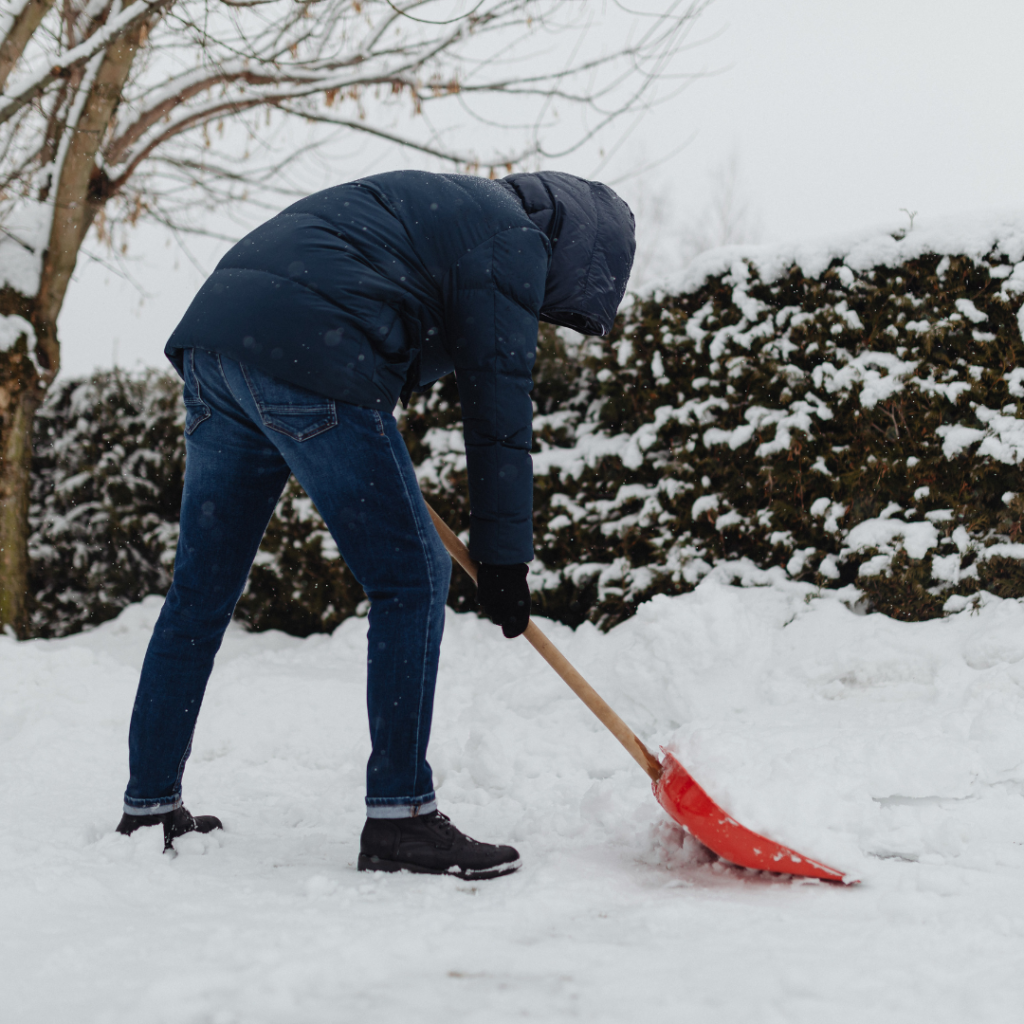 Person using safe form to prevent snow shoveling injuries during Maine winter.