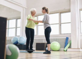 Older adult improving balance training fall risk with a physical therapist.