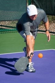 pickleball player lunging during game showing need for injury prevention Title: